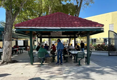 Covered pavilion provides shade for domino players in the heart of the park