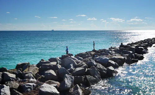 A rocky breakwater extends far into the ocean