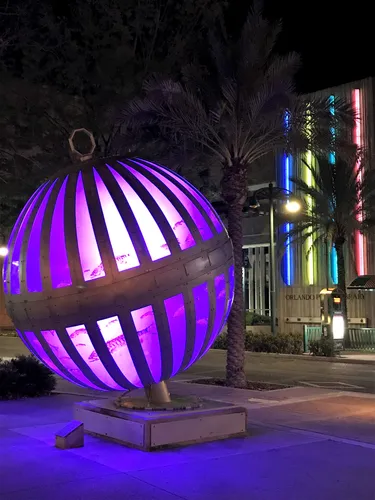 Purple lights illuminate the Global Convergence Sculpture at night