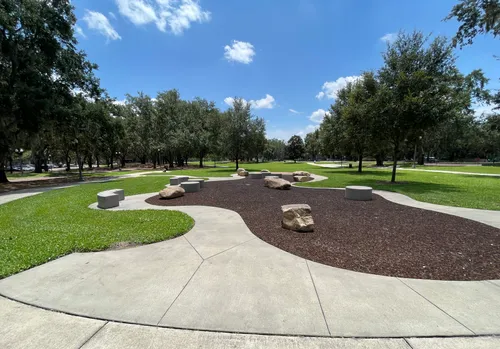 Open green lawns and winding paths stretch through the park