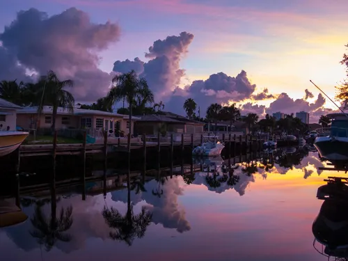 Boats moored along the calm waterway under a breathtaking purple sky