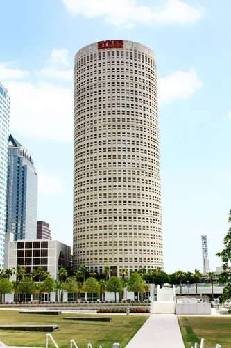 The cylindrical Rivergate Tower rises beyond the park grounds
