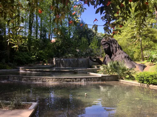 Peaceful pond setting at the Cascades Garden with the Earth Goddess sculpture