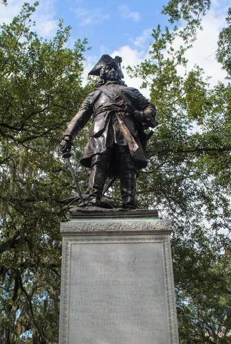 Historic statue of James Oglethorpe stands amid greenery in Chippewa Square