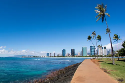 Walking path along the shore with Honolulu skyline in distance