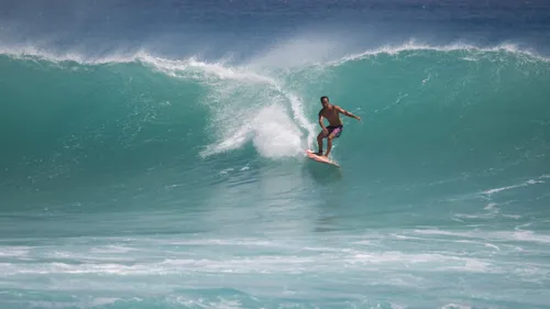 A surfer rides an enormous wave
