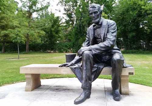 Abraham Lincoln statue seated on a bench east of the Black History Museum