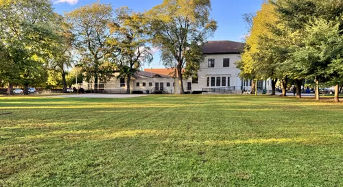 Armour Park Fieldhouse seen behind the open lawn