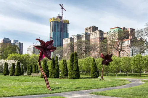 Red Lily sculptures by Dessa Kirk bloom among greenery