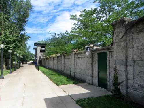Sunlit pathway alongside a concrete wall