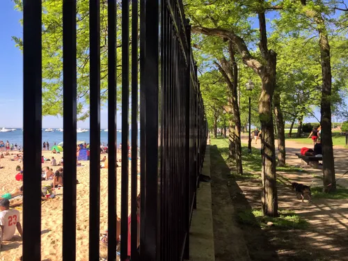Ohio Street Beach is visible through the iron fence along the walkway