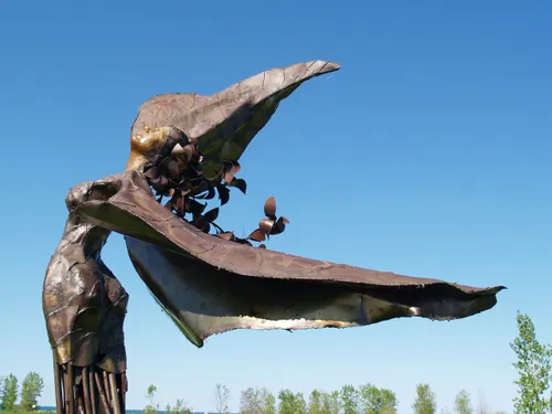 Wing-like arms stretch skyward on this metal sculpture