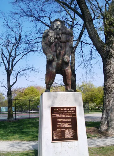 The Cowardly Lion bronze sculpture next to the tennis courts