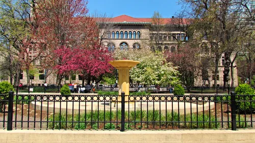Blooming trees and the historic Newberry Library can be seen behind the park's central fountain