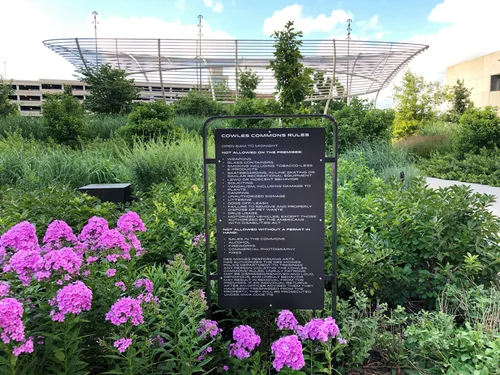 Informational plaque and vibrant flowers with the iconic Swirl structure visible beyond