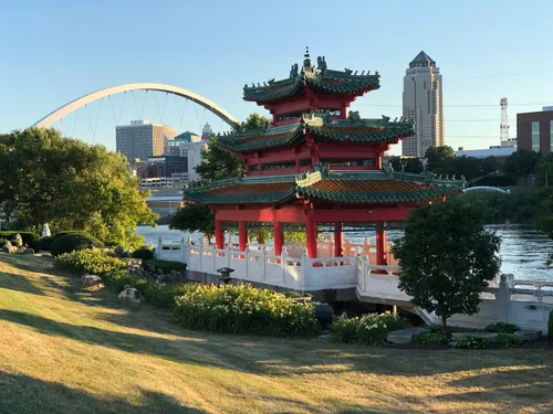 The Chinese pavilion sits by the Des Moines River in warm evening light