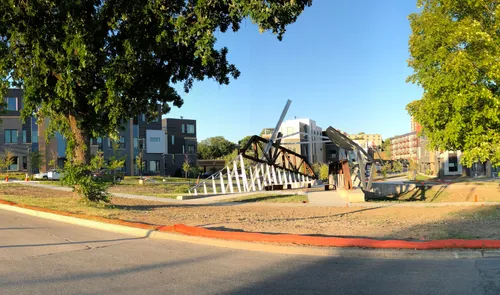 A sculpture bridge by Dennis Reynolds is the centerpiece of the Bridge District park area