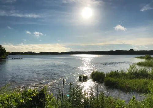 Sunlight reflects off Blue Heron Lake with marsh grasses along the shore