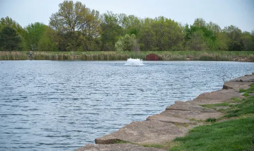 A stone shoreline marks the western edge of Stoll Park Lake