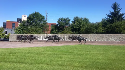 Life-size thoroughbred statues racing through the park