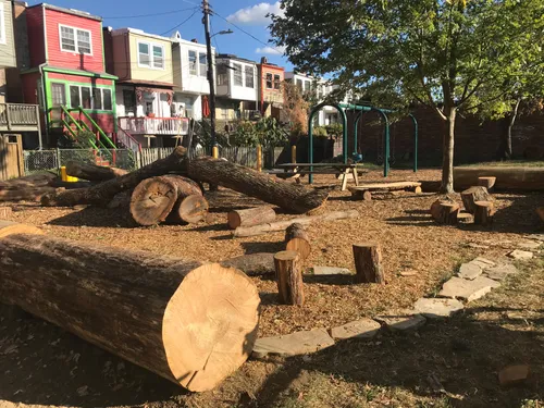 Large logs and wood stumps arranged as natural play features in the park