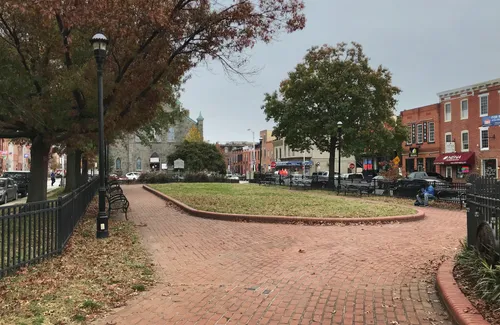 The central brick pathway curves around lawn islands