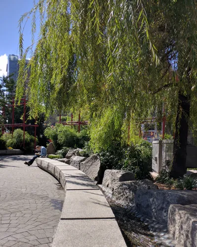 A weeping willow frames this view along the park's curved stone-edged walkway