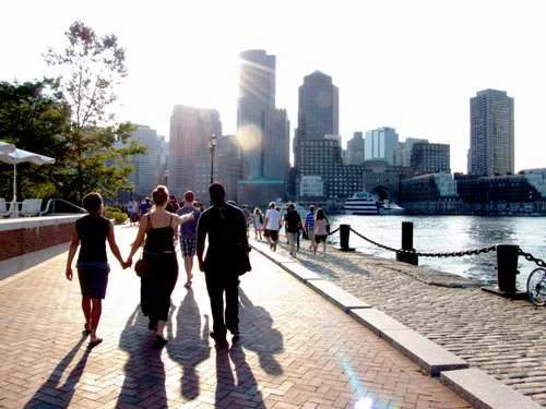 Visitors strolling along the waterfront toward downtown Boston