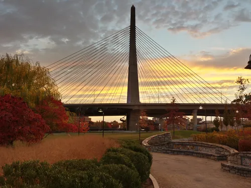Sunset softly illuminates the park landscape with the Zakim Memorial Bridge behind