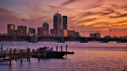 Sunset bathes the Back Bay skyline in golden-purple light across the Charles