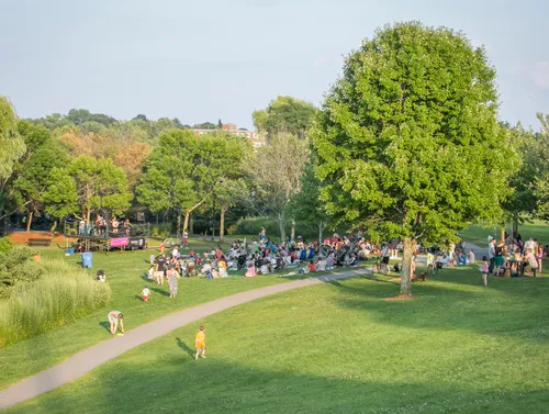 Visitors enjoy the green open spaces on a sunny afternoon at the park