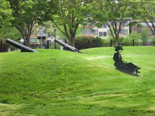 Grassy slopes with cannons visible in the background
