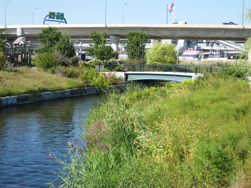 Riverbank with transportation infrastructure visible beyond