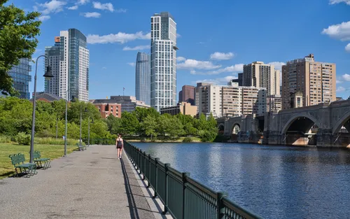 Boston skyline and Lechmere Viaduct visible from the riverfront promenade