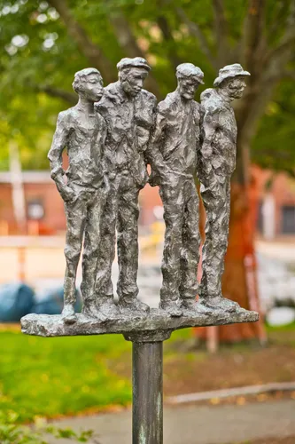 Workers sculpture by Gene Cauthen depicts four bronze figures atop a steel pole