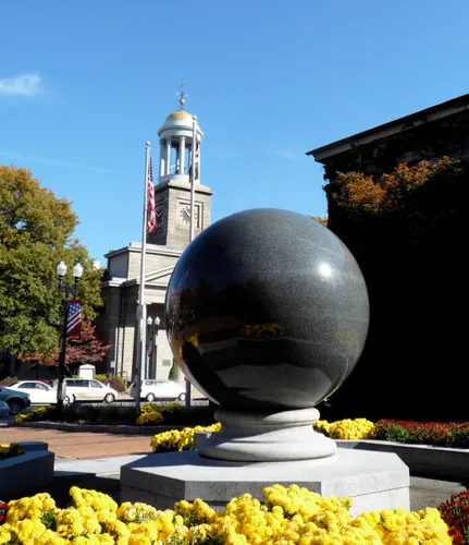 The Gazing Ball granite sphere with United First Parish Church in the background
