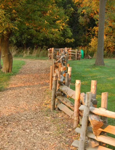 A split-rail fence lines a small path through the park's grounds