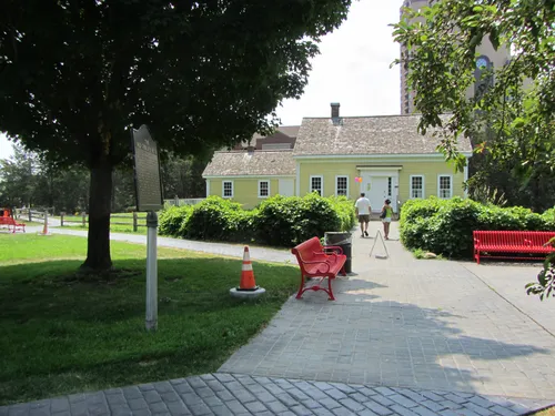 Pathway leading to the historic Ard Godfrey House with red benches nearby