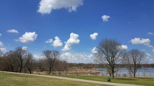A path curves through the park along the open waters of the lake