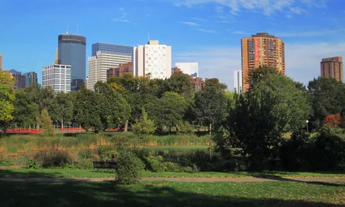 The Minneapolis skyline rises above the park landscape