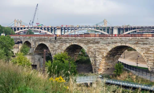 The historic Stone Arch Bridge with a park walkway beneath