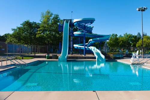 The water park's blue slides tower over the pool on a clear sunny day