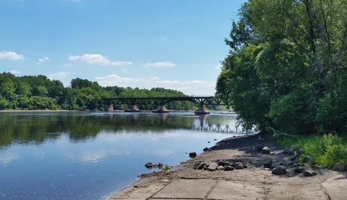 The Mississippi River shoreline with the Canadian Pacific Camden Place Rail Bridge visible in the distance