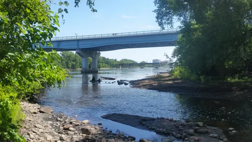 Camden Bridge spans the Mississippi River, seen from the rocky shoreline below
