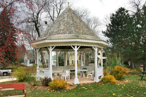 A charming white gazebo surrounded by autumn foliage at the park