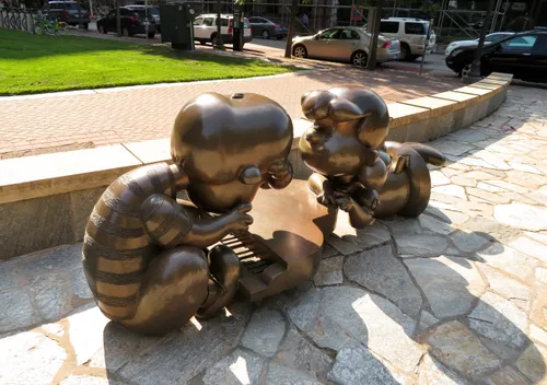 Bronze Peanuts characters Schroeder and Lucy interact at Landmark Plaza