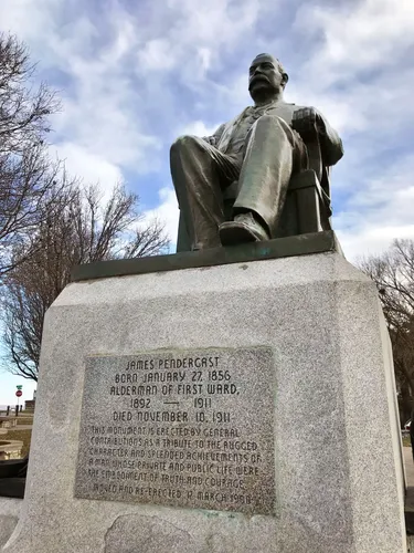 The seated bronze memorial to James Pendergast atop a granite pedestal