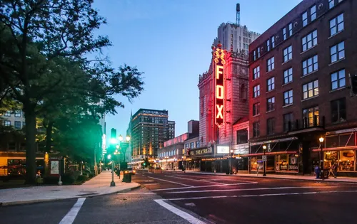 The iconic Fox Theatre sign glows along Grand Boulevard at dusk
