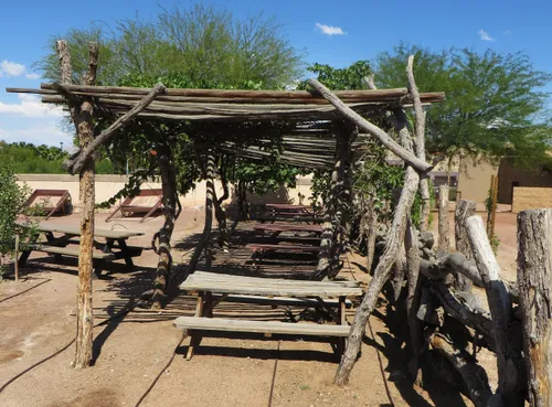 Wooden tables under a shaded structure at the park