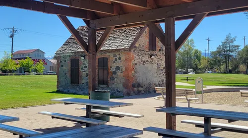 Picnic tables rest under the park's wooden shelter